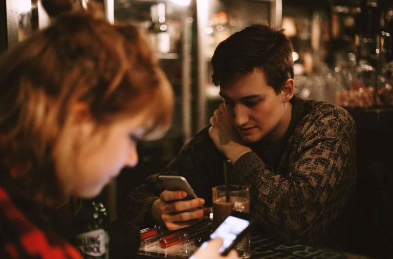people using mobile phones in a cafe