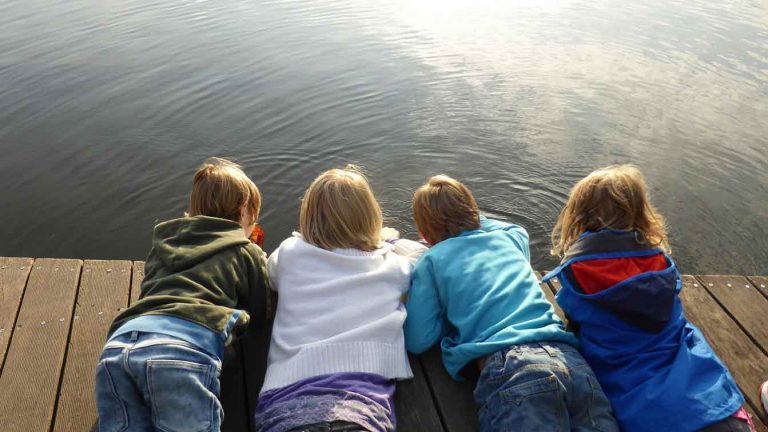 young friends playing by the water