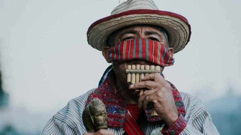 South American man playing panpipes