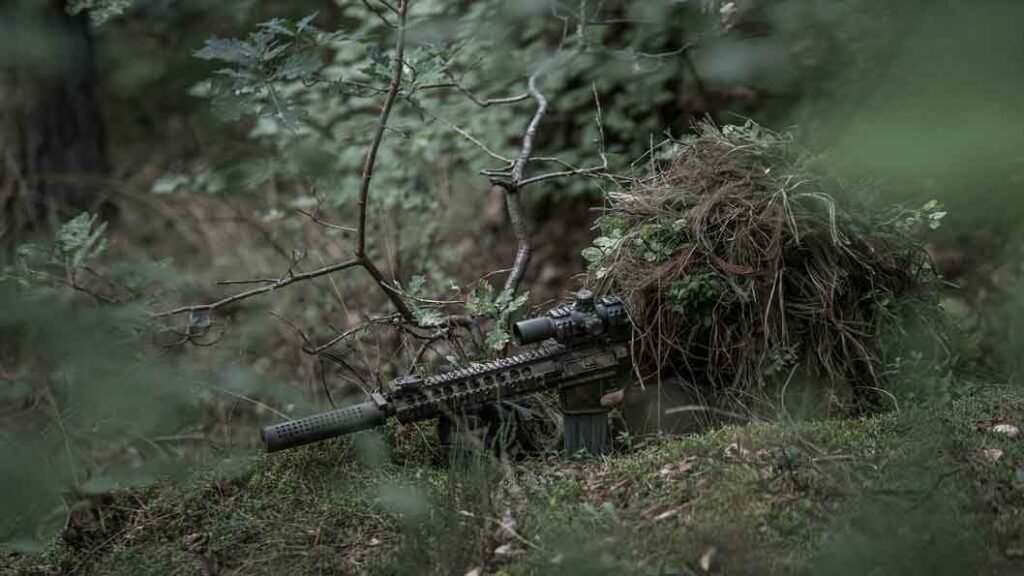 a sniper hiding in camouflage