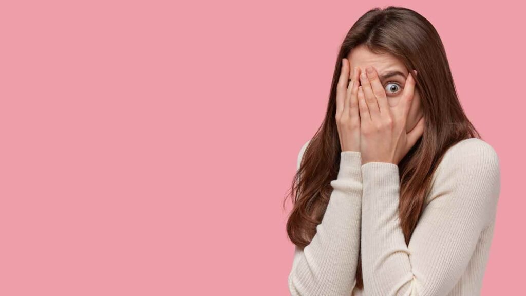 a woman covering her face in fear