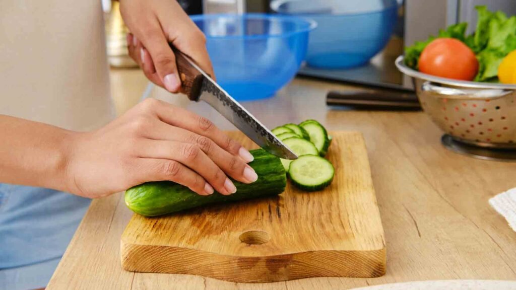 a man cutting cucumber to cook