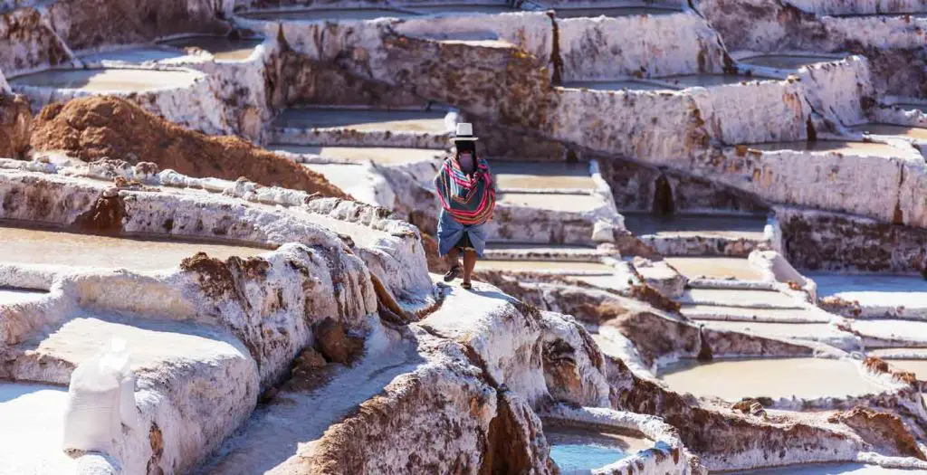 a person walking around salt ponds in Peru