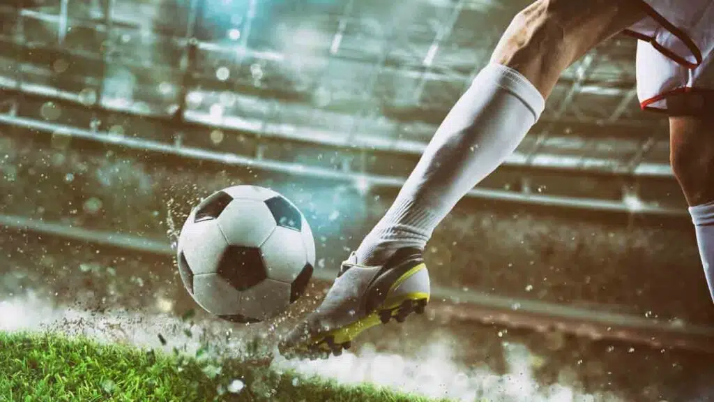 a soccer player kicking a football