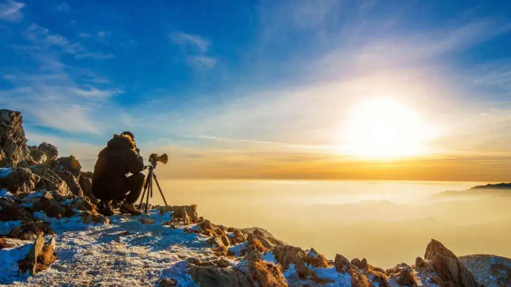 photographer on a mountain at sunset